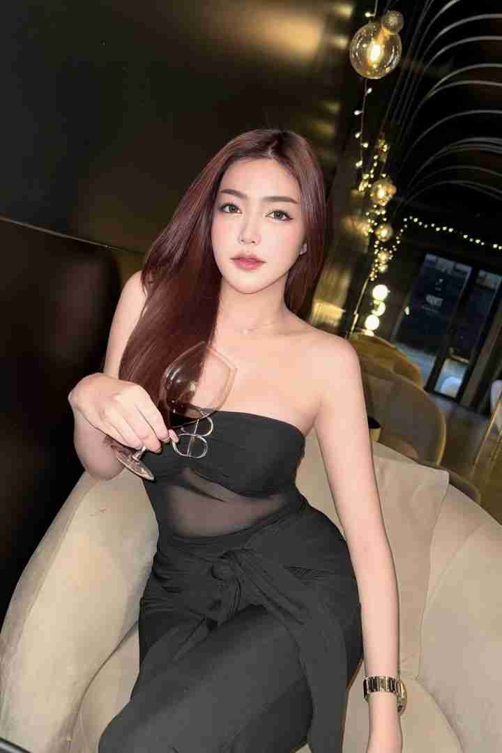 KL Escort Girl Woman in black dress holding wine glass. Elegant ambiance. Malaysia Sex Call Girl