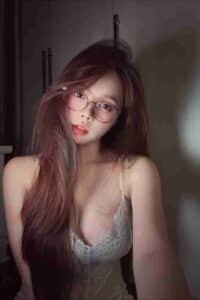 KL Escort Girl Woman with glasses and long hair wearing a white lace top. Malaysia Sex Call Girl