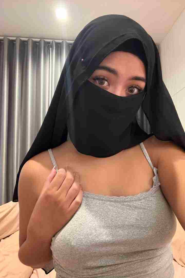 KL Escort Girl Woman in hijab and tank top, bedroom setting. Malaysia Sex Call Girl
