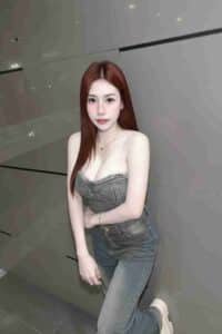 KL Escort Girl Woman in denim outfit leaning against a wall Malaysia Sex Call Girl