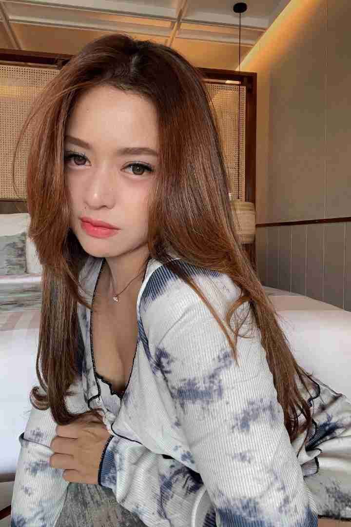 KL Escort Girl Attractive woman with auburn hair wearing a tie-dye top. Malaysia Sex Call Girl