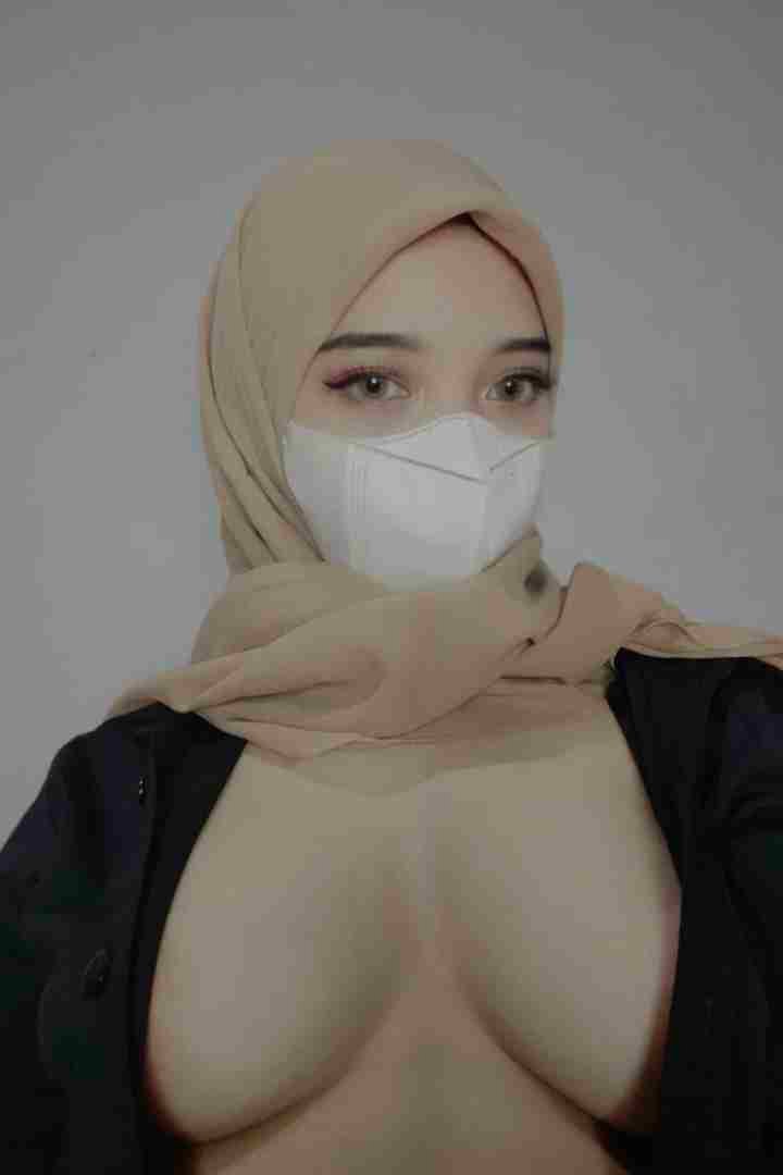 KL Escort Girl Woman wearing hijab and mask, low-cut top. Malaysia Sex Call Girl
