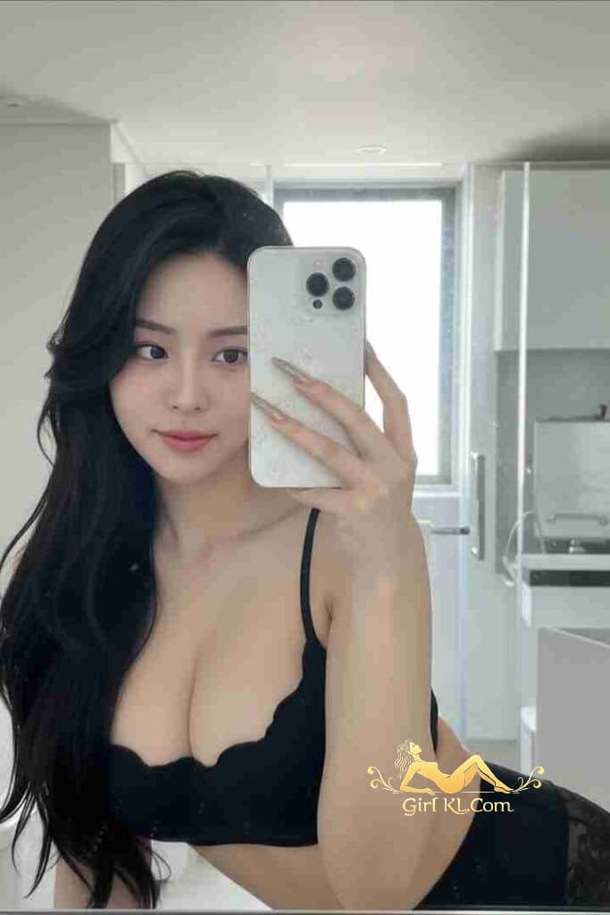 Elegant Asian woman in black lingerie takes a selfie in a modern bathroom. Long dark hair.