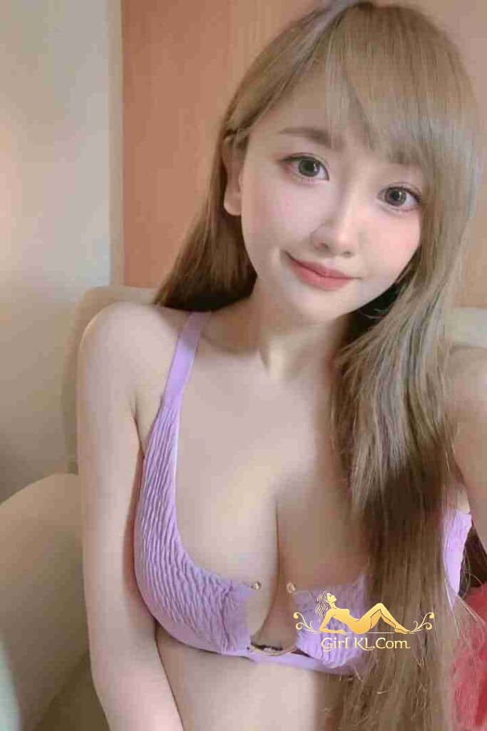 Attractive Asian woman with blonde hair, wearing a lavender top, smiling at the camera.