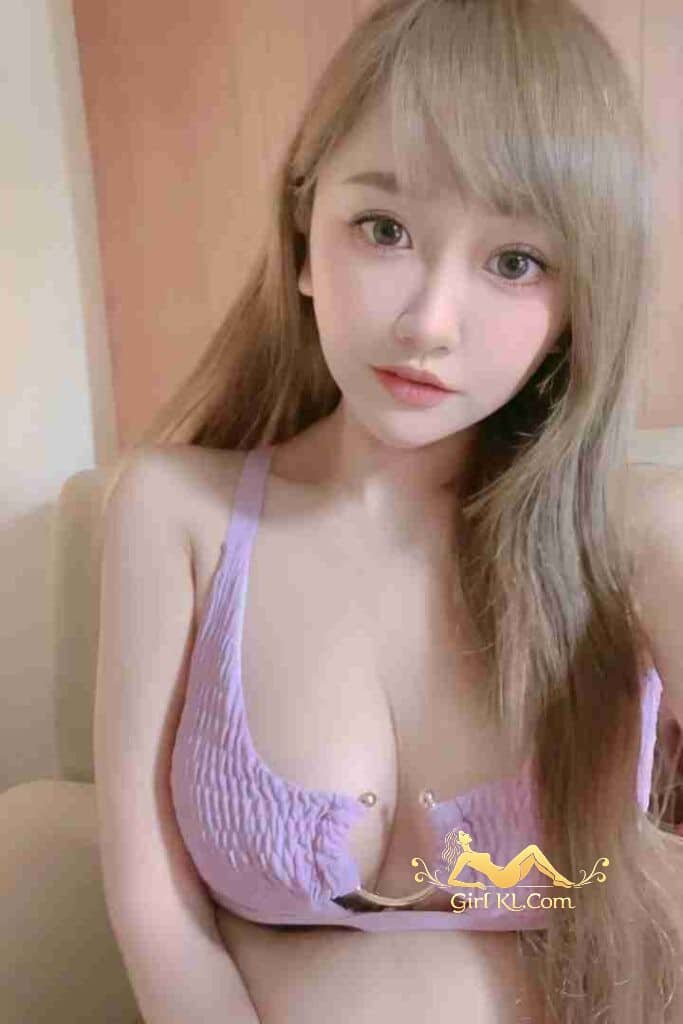 Attractive Asian woman with blonde hair wearing a light purple top. Portrait shot.