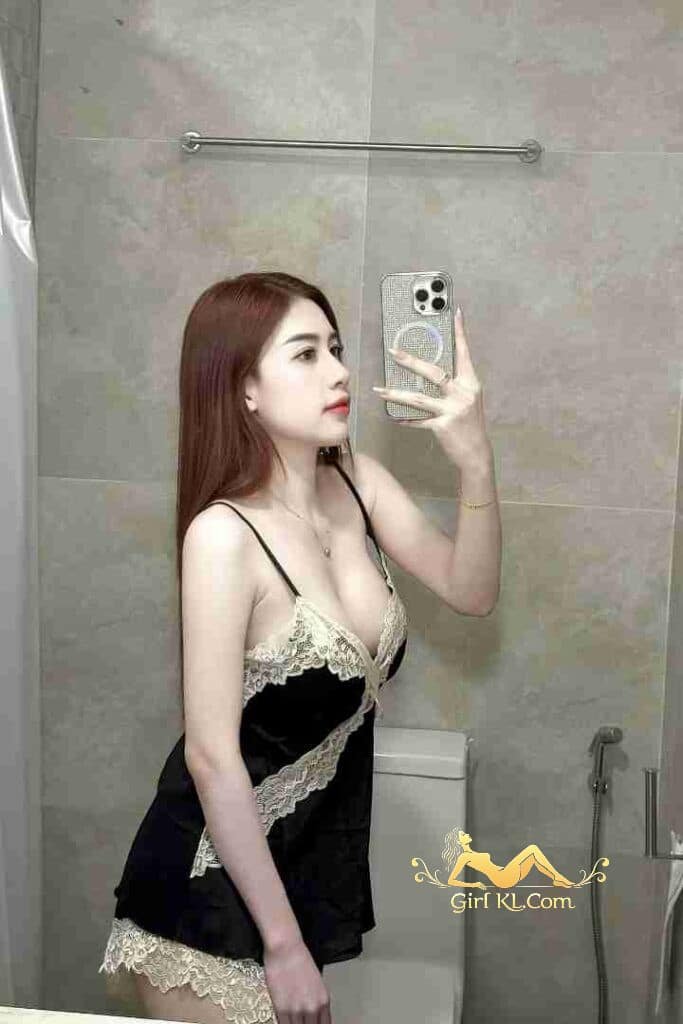 Attractive Asian woman in lingerie taking a selfie in bathroom.
