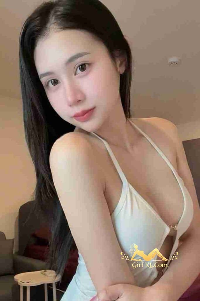 Beautiful Asian woman with long dark hair in white dress, looking at the camera.