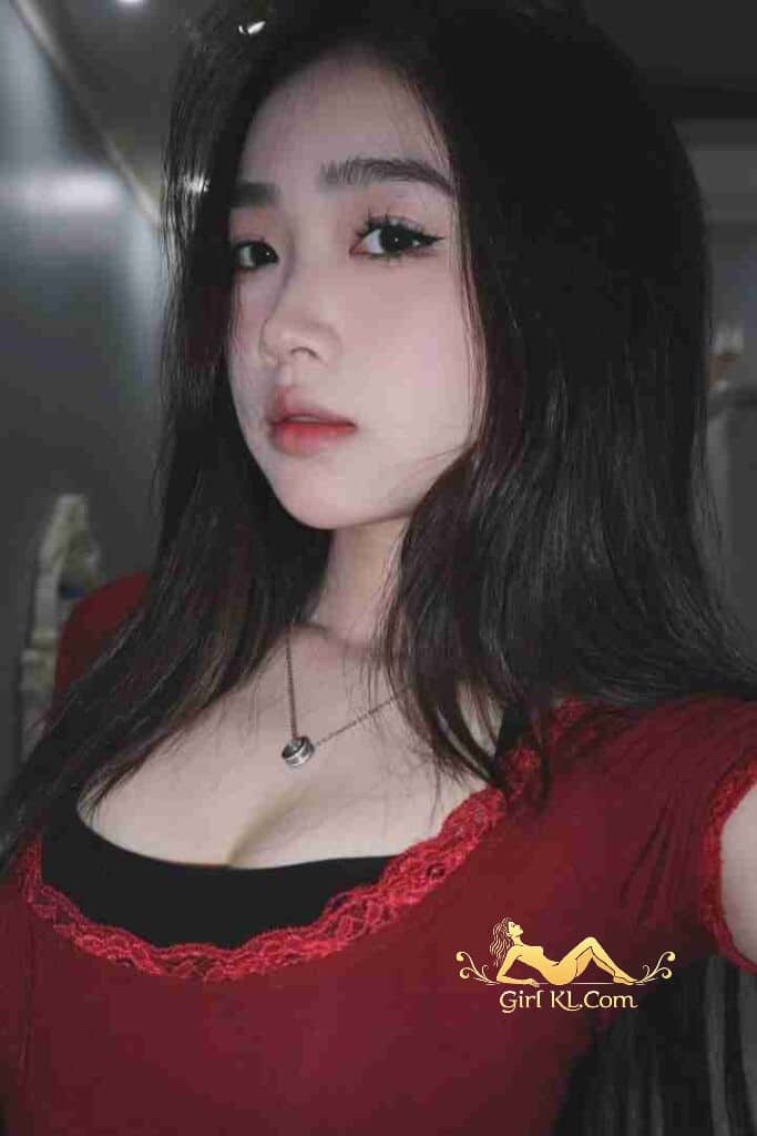 Attractive young Asian woman with dark hair and red top, wearing a necklace.