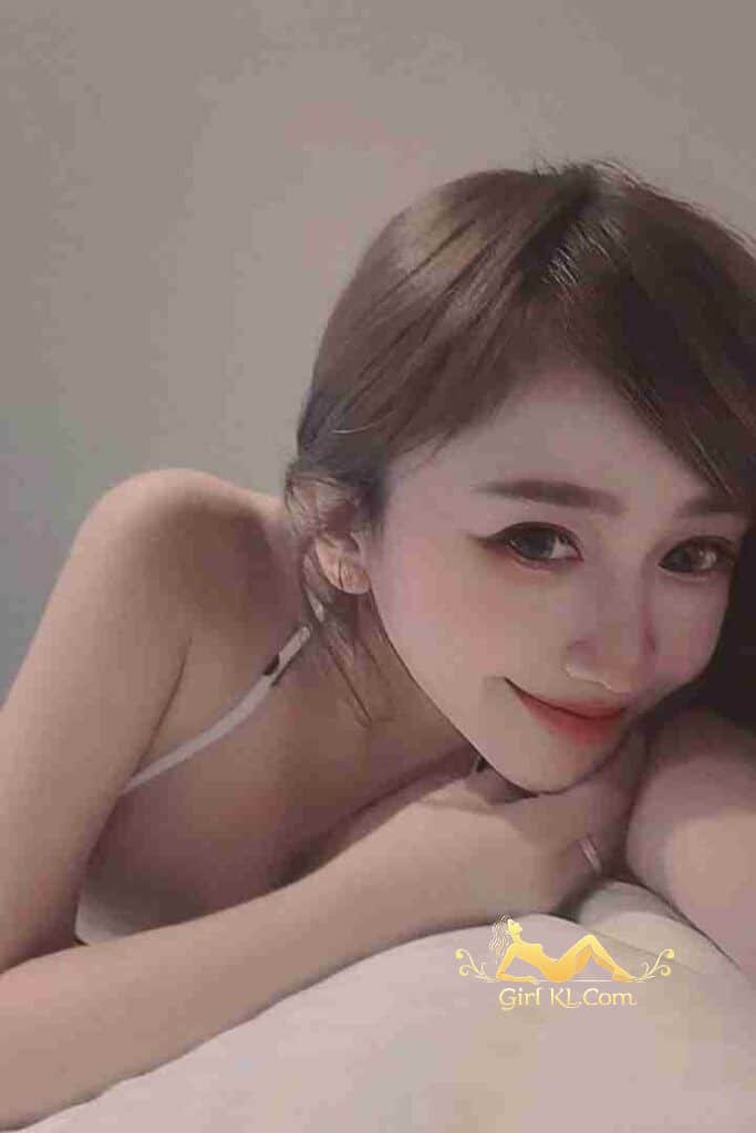 Attractive young Asian woman with a soft smile, posing intimately.