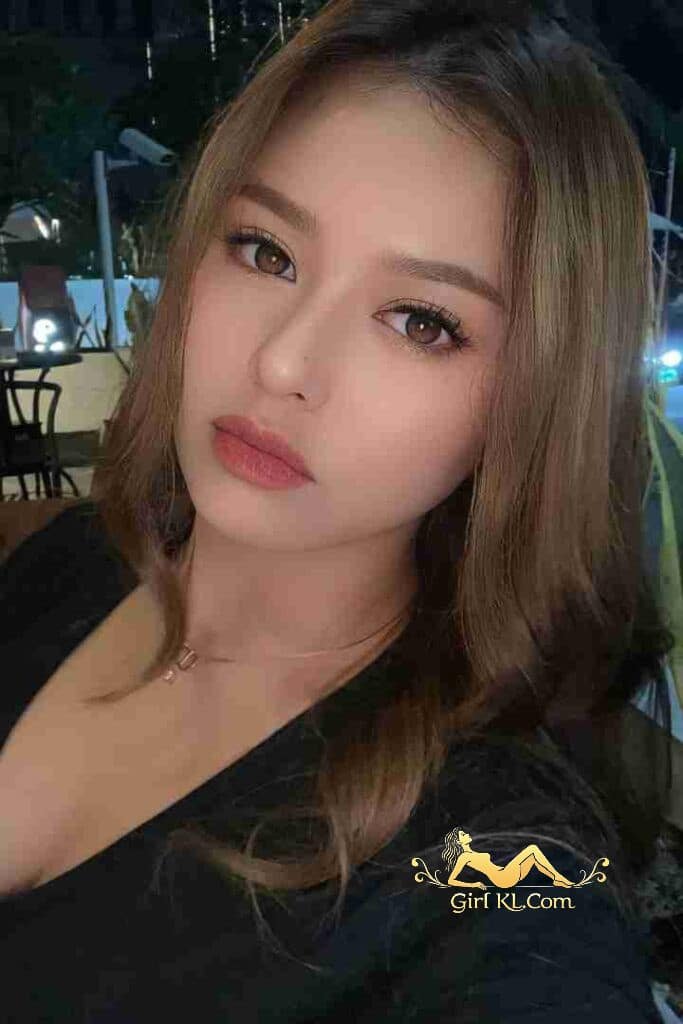 Close-up of a beautiful Malay girl with brown hair and eyes, wearing a black top.