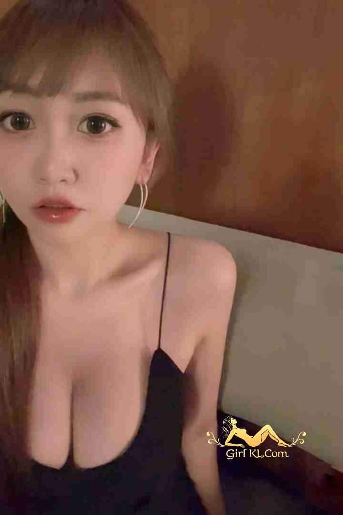 Attractive Chinese woman with bangs in black dress, KL escort profile.