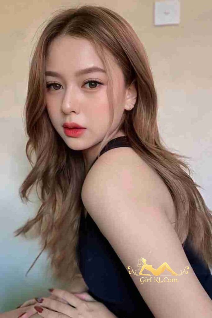 Beautiful Malay girl Safiyyah with long brown hair and coral lipstick looking at the camera.