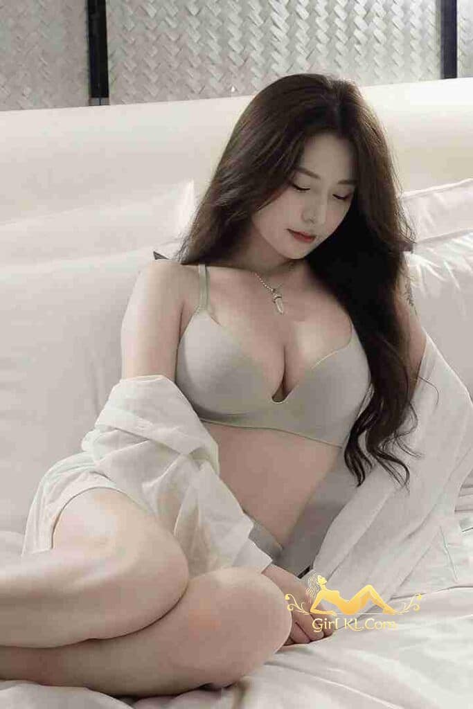 Petite Yu Xin in bra and shirt on bed. Kuala Lumpur escort.