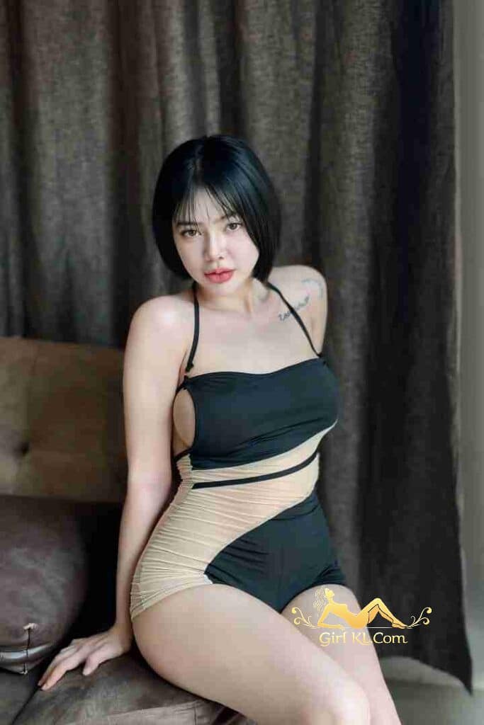 Attractive Thai woman in stylish black and beige swimsuit, posing seductively. Dark bob haircut, red lips.