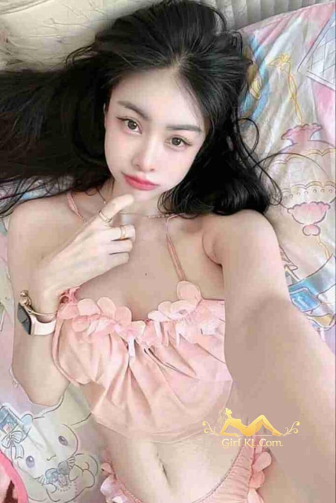 Beautiful Thai woman Gina in pink lingerie lying on bed. KL escort incall/outcall services.