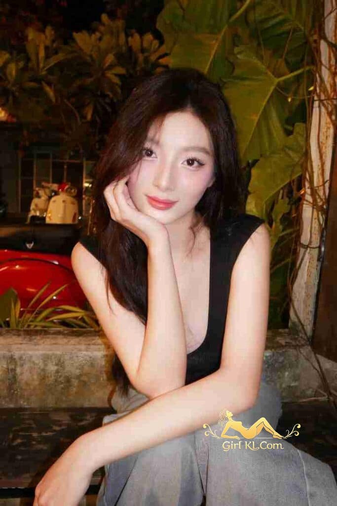 Beautiful Vietnamese woman with long dark hair posing outdoors.