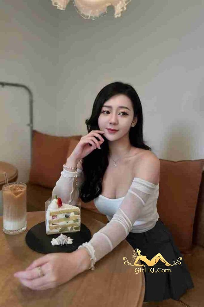Woman with cake and drink at cafe. Elegant style, black hair, white top, dessert, and beverage.