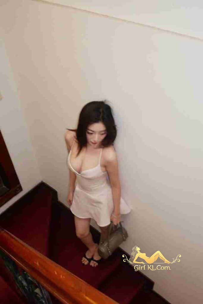 Woman in dress on stairs with purse.