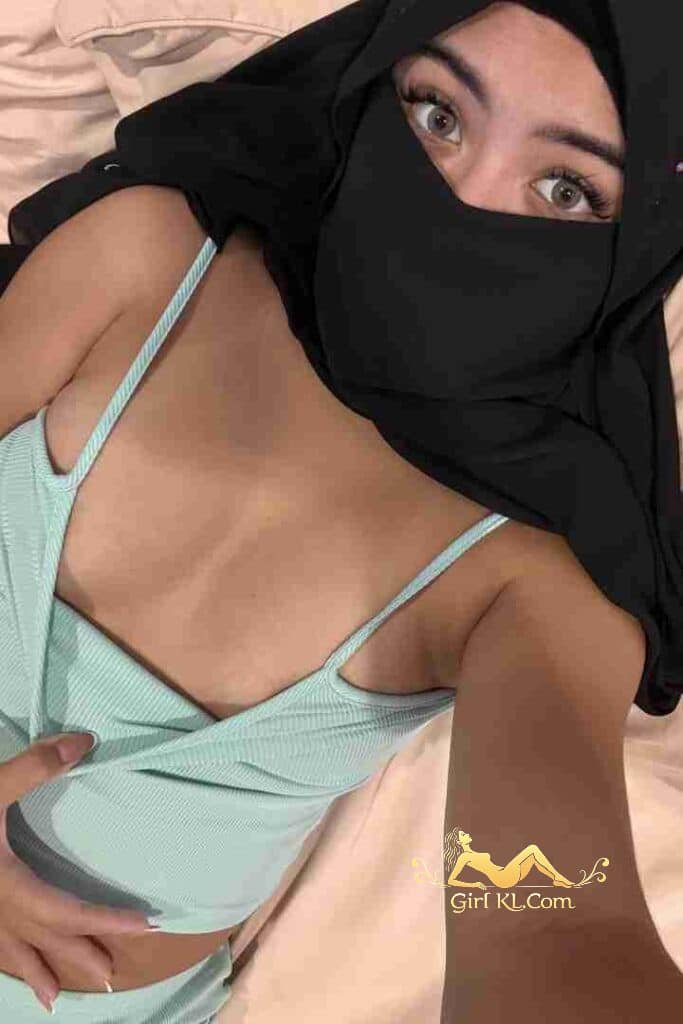 Woman in hijab and light blue top. Eyes visible.