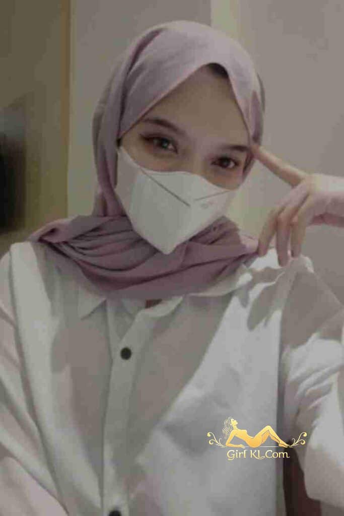 Woman in hijab and mask wearing a white button-down shirt.
