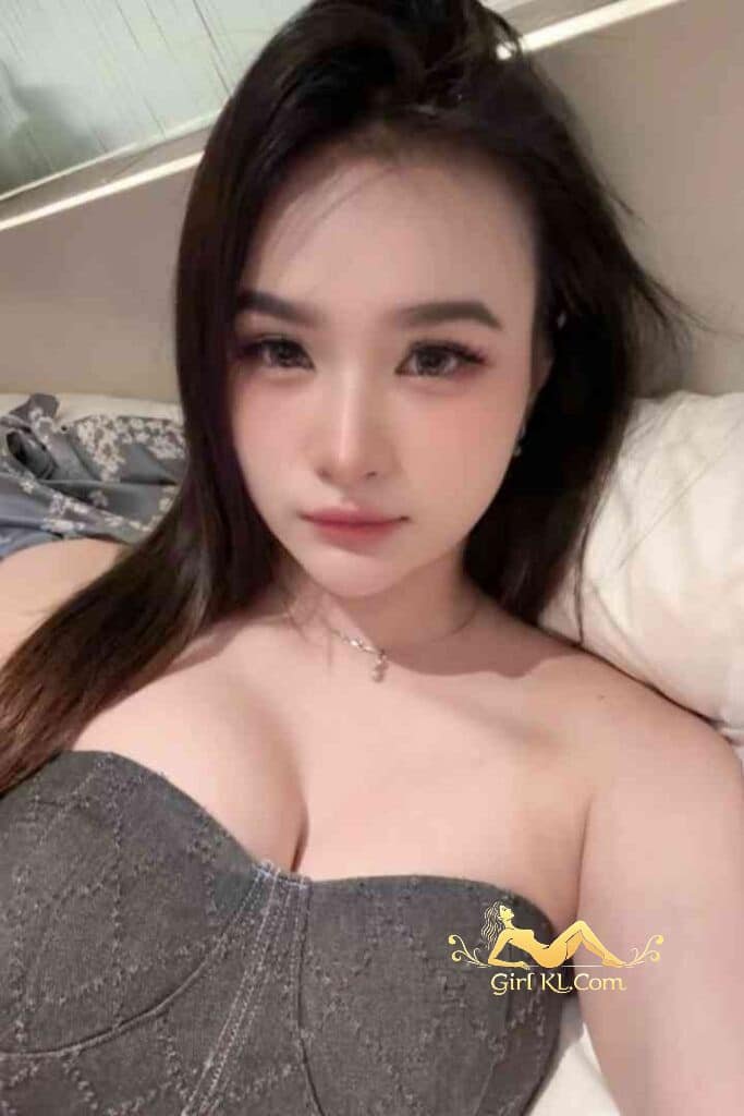 Attractive young Asian woman with dark hair and strapless top, lying down.